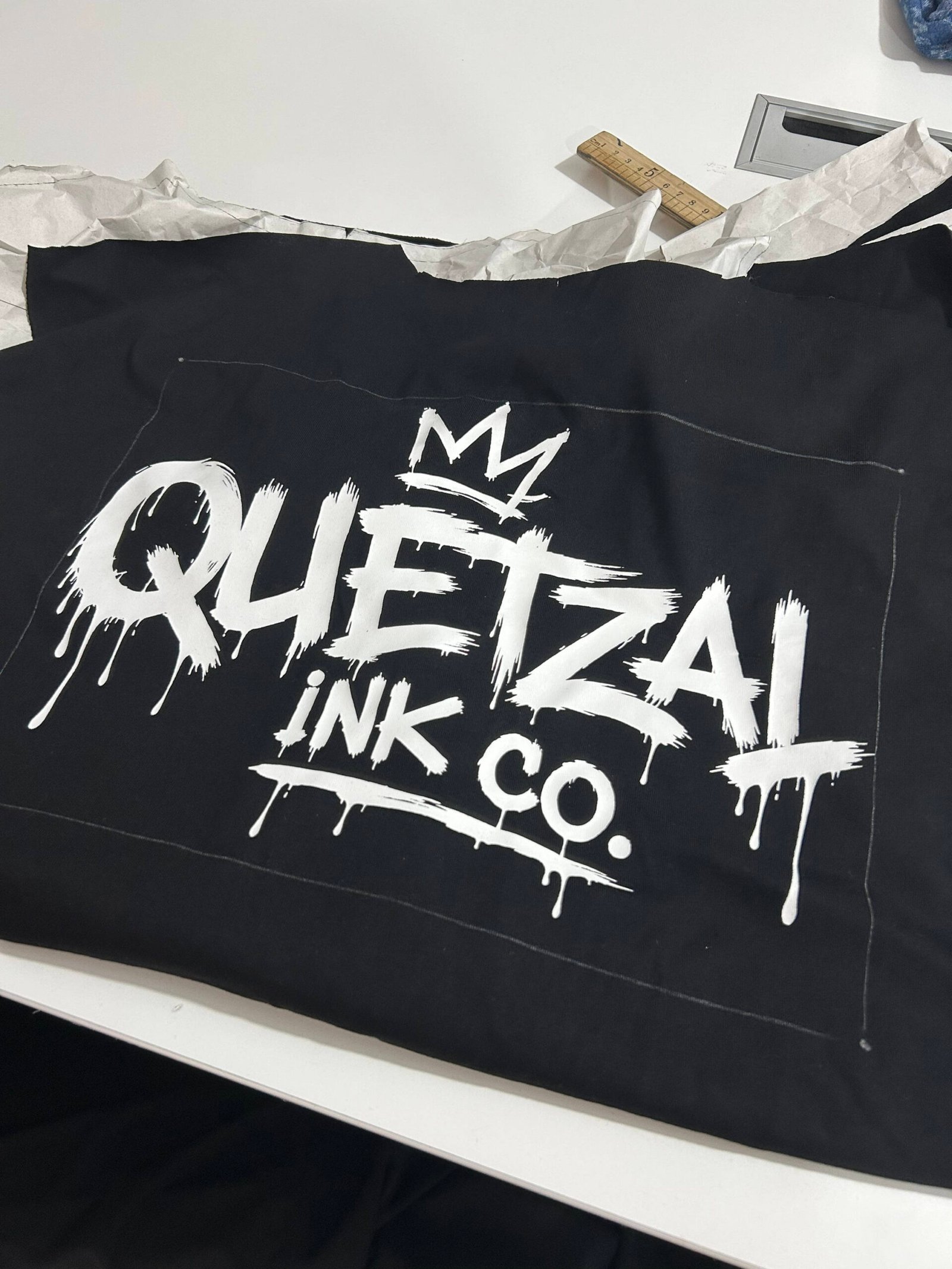 White graphic screen printing test on black fabric for custom streetwear production