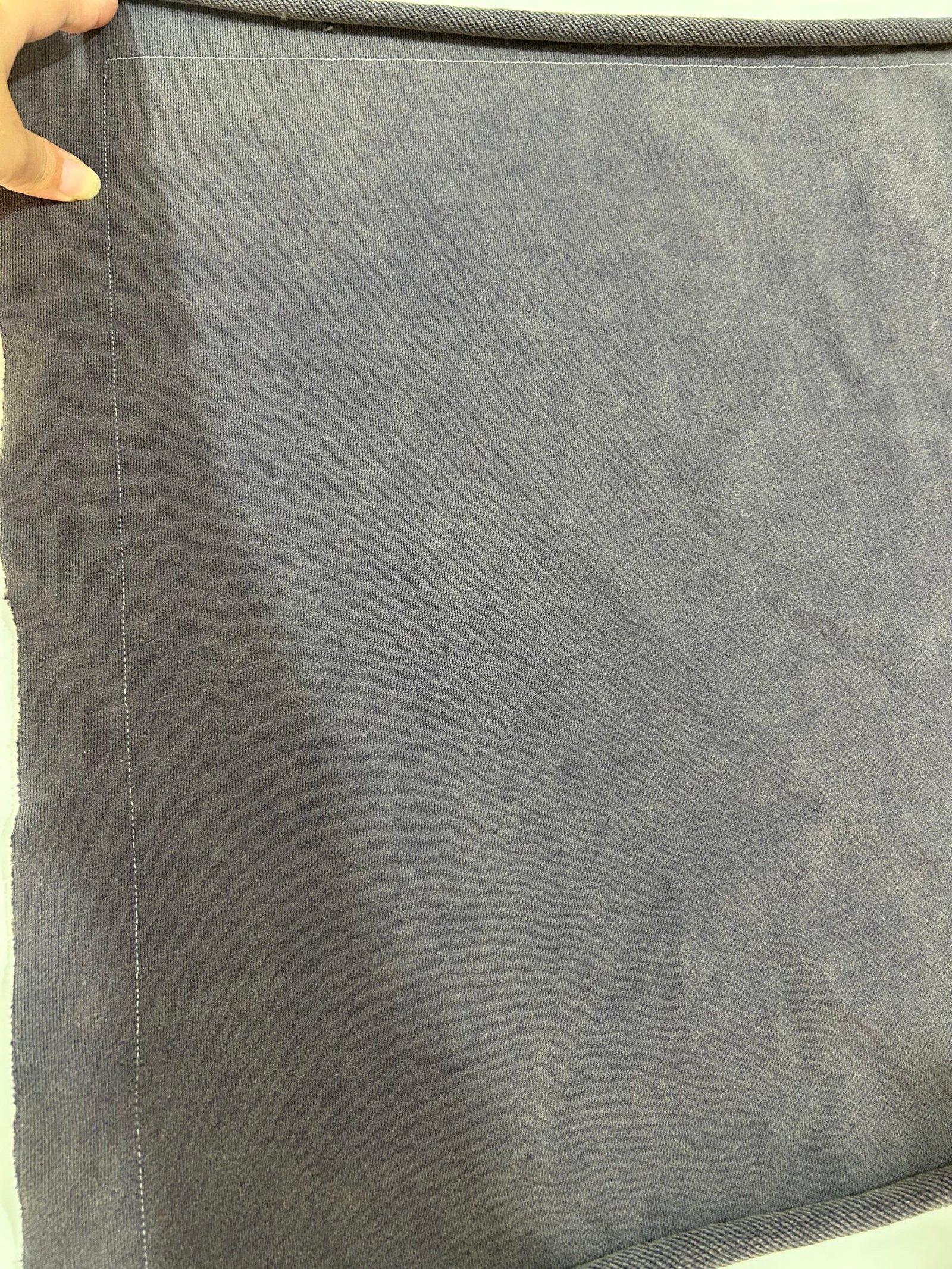 Dark grey fabric prepared for shrinkage testing before salt washed garment manufacturing